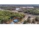 High-angle view of a property with a blue house, trees, and a road at 5250 Little Green Ln, Dade City, FL 33523