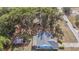 An aerial view of a house with a gray roof, a red shed, and trees at 5250 Little Green Ln, Dade City, FL 33523