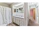 Bathroom featuring white vanity, dual mirrors, shower/tub combo, and updated flooring at 5250 Little Green Ln, Dade City, FL 33523