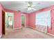 Spacious bedroom with pink walls, ceiling fan, and carpeted floors at 5250 Little Green Ln, Dade City, FL 33523