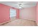 Pink bedroom with carpet, ceiling fan, and window with lace curtains at 5250 Little Green Ln, Dade City, FL 33523