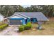 Charming blue home with stone facade, attached garage, and wishing well at 5250 Little Green Ln, Dade City, FL 33523