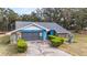Charming blue home with a stone facade, attached garage, and landscaped front yard at 5250 Little Green Ln, Dade City, FL 33523