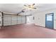 Two-car garage with pink flooring and white walls at 5250 Little Green Ln, Dade City, FL 33523
