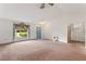 Open living room with neutral carpet, high ceilings, ceiling fan, and ample natural light at 5250 Little Green Ln, Dade City, FL 33523