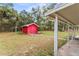 Red shed in the backyard with a covered patio area at 5250 Little Green Ln, Dade City, FL 33523