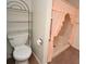 A bathroom featuring an accessible walk-in shower with pink curtains and a toilet at 5250 Little Green Ln, Dade City, FL 33523