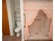 A bathroom featuring an accessible walk-in shower with pink curtains at 5250 Little Green Ln, Dade City, FL 33523