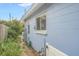 Side view of a light blue house with a white door and landscaping at 6110 2Nd S Ave, St Petersburg, FL 33707