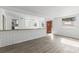 Open-concept living area showcasing stylish flooring, an adjacent kitchen, and abundant natural light at 7235 12Th N Ave, St Petersburg, FL 33710
