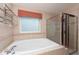 Bathroom with soaking tub, shower, and window at 7612 Nottinghill Sky Dr, Apollo Beach, FL 33572