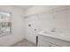 Bright laundry room with a utility sink, shelving, and natural light at 8723 Terracina Lake Dr, Tampa, FL 33625