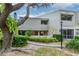 Inviting condo exterior featuring lush landscaping, mature trees, and a private balcony at 8737 Bardmoor Pl # 101, Seminole, FL 33777