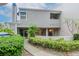 Exterior view of gray two-story condo with a walkway, patio and lush landscaping at 8737 Bardmoor Pl # 101, Seminole, FL 33777