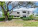 Inviting condo exterior featuring lush landscaping, mature trees, and a private balcony at 8737 Bardmoor Pl # 101, Seminole, FL 33777
