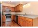 Charming kitchen featuring stainless steel appliances, wood cabinets, and modern lighting at 8737 Bardmoor Pl # 101, Seminole, FL 33777