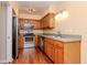 Kitchen featuring stainless steel appliances, wood cabinets, and modern lighting at 8737 Bardmoor Pl # 101, Seminole, FL 33777