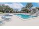 Community pool with spa and lounge chairs surrounded by lush landscaping at 8737 Bardmoor Pl # 101, Seminole, FL 33777