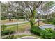 View from porch overlooking street with mature trees and landscaping at 8737 Bardmoor Pl # 101, Seminole, FL 33777