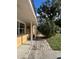 Side view showcasing a walkway leading to the entrance of a charming yellow house at 8823 W Robson St, Tampa, FL 33615