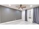 Bedroom with gray accent wall, light wood floors, ceiling fan and window with layered curtains at 9100 Dr Martin Luther King Jr N St # 1706, St Petersburg, FL 33702
