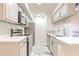 Modern kitchen features stainless steel appliances, white cabinetry, stone countertops, and elegant flooring at 9100 Dr Martin Luther King Jr N St # 1706, St Petersburg, FL 33702