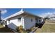 Well-maintained home featuring a lush lawn, tidy landscaping, and a screened-in porch on a bright, sunny day at 9350 Mainlands W Blvd, Pinellas Park, FL 33782