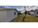 Rear view featuring lawn, siding, and glimpse of a screened in porch at 9350 Mainlands W Blvd, Pinellas Park, FL 33782