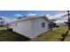 Rear view featuring lawn, siding, and glimpse of a screened in porch at 9350 Mainlands W Blvd, Pinellas Park, FL 33782