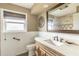 Bathroom featuring vanity, window, commode, and decorative mirror at 945 Bayshore Dr, Tarpon Springs, FL 34689