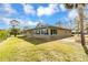 Exterior view of a single-story house with a large lawn and trees at 945 Bayshore Dr, Tarpon Springs, FL 34689