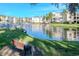 Serene lakefront view with lush landscaping and a bench at 14130 Rosemary Ln # 5301, Largo, FL 33774