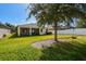 Large backyard, home with covered patio, grassy area, and tree at 17766 Garsalaso Cir, Brooksville, FL 34604