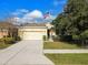House front with a two-car garage and American flag at 17766 Garsalaso Cir, Brooksville, FL 34604