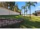 Landscaped backyard with retaining wall and lake view at 204 Mystic Falls Dr, Apollo Beach, FL 33572