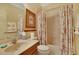 Bathroom with floral shower curtain, wood vanity, and bathtub at 204 Mystic Falls Dr, Apollo Beach, FL 33572