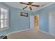 Light blue bedroom with carpeting, window seat, and door to hallway at 204 Mystic Falls Dr, Apollo Beach, FL 33572