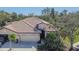 Exterior view of a house with a two-car garage and tile roof at 204 Mystic Falls Dr, Apollo Beach, FL 33572