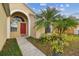 Inviting front entry with a red door and lush landscaping at 30009 Morningmist Dr, Wesley Chapel, FL 33543