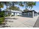 Front view of a light blue house with carport and landscaping at 3636 Trophy Blvd # 3636, New Port Richey, FL 34655