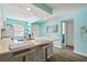 Bright teal kitchen with white cabinets, quartz countertops, and breakfast bar at 3636 Trophy Blvd # 3636, New Port Richey, FL 34655