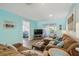 Bright living room with comfy seating, TV, and view into bedroom at 3636 Trophy Blvd # 3636, New Port Richey, FL 34655
