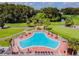 Kidney-shaped pool with patio furniture and umbrellas at 3636 Trophy Blvd # 3636, New Port Richey, FL 34655