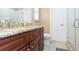 Modern bathroom with granite countertop, wooden cabinetry, and a glass shower at 6512 Manila Palm Way, Apollo Beach, FL 33572