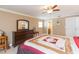 Well-appointed bedroom showcasing wooden furniture, ceiling fan, and an ensuite bathroom at 6512 Manila Palm Way, Apollo Beach, FL 33572