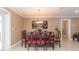 Dining room with dark wood ornate table and red chairs with a decorative art piece on the wall at 6512 Manila Palm Way, Apollo Beach, FL 33572