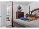 Main bedroom with four-poster bed, dresser, and view of bathroom at 7901 Sugarcane Ct, Temple Terrace, FL 33637