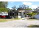 House with a red truck parked in front, a fenced yard, and solar panels on the roof at 8123 N Packwood Ave, Tampa, FL 33604