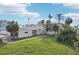 Large backyard with mature palm trees and a spacious lawn at 15825 Redington Dr, Redington Beach, FL 33708