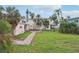 Brick patio, grassy yard, and home's rear elevation at 15825 Redington Dr, Redington Beach, FL 33708